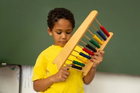 Schoolboy learning mathematics with abacus in a classroom Stockfoto's