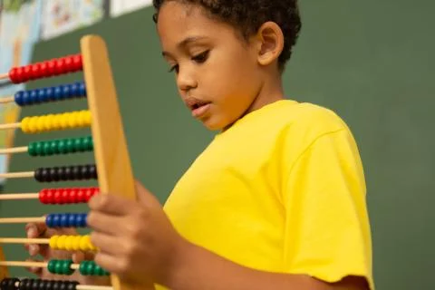Schoolboy learning mathematics with abacus in a classroom Foto stock