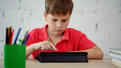 The schoolboy looks at the tablet Stock Footage 92044061