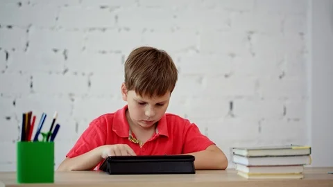 The schoolboy looks at the tablet Stock Footage 92044352