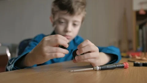 Schoolboy looks to wheels off disassembled model supercar Stock Footage 129403478