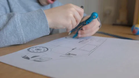 Schoolboy make homework and using drawing compass and ruler to draw a car Stock Footage 129012435
