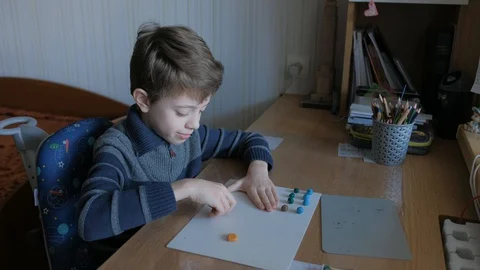Schoolboy models the geometric shapes from plasticine and matches. Stock Footage 128988896