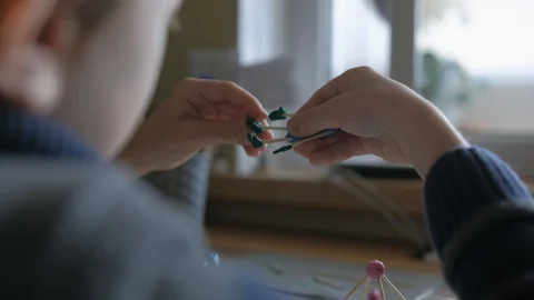 Schoolboy models the geometric shapes from plasticine and matches. Stock Footage 128988909