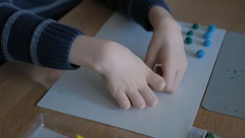 Schoolboy models the geometric shapes from plasticine and matches. Stock Footage 128988916