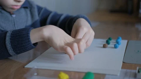 Schoolboy models the geometric shapes from plasticine and matches. Stock Footage 128988923