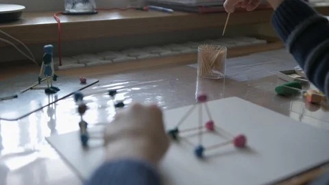 Schoolboy models the geometric shapes from plasticine and matches. Stock Footage 128988934