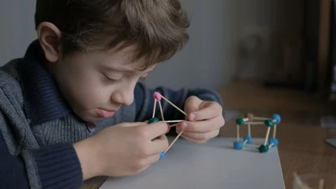 Schoolboy models the geometric shapes from plasticine and matches. Stock Footage 128988953