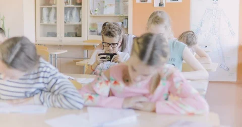 Schoolboy Playing Games on a Smartphone in the Classroom. Stock Footage 97340866