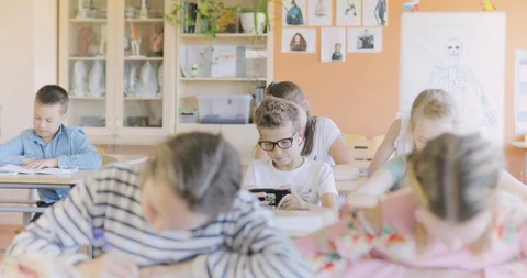 Schoolboy Playing Games on a Smartphone in the Classroom Stock Footage 97340943