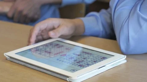 Schoolboy plays the game using the digital tablet 스톡 동영상 69809623