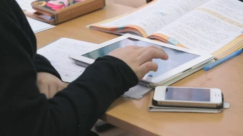 Schoolboy plays games on white computer tablet Stock Footage 77696478