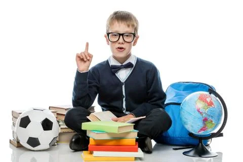 Schoolboy posing on white background with a bunch of books Foto stock