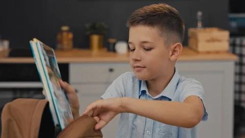 Schoolboy puts in a backpack textbooks, exercise books, lunch. Back to School. Video stock 92839921