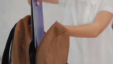 Schoolboy puts a tablet computer in a backpack. Back to School. Stock Footage 92734323