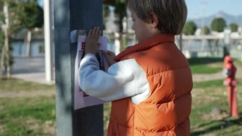 Schoolboy putting up missing pet banners 動画素材 229162524