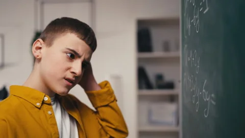Schoolboy puzzled with a math problem, bad at algebra, difficult task, trouble Stock Footage 250334423