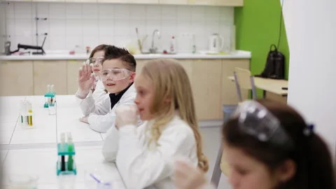 Schoolboy raising hand to answer the question in chemistry class Video stock 86276635