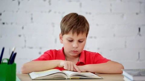 A schoolboy reading a textbook Stock Footage 92041597