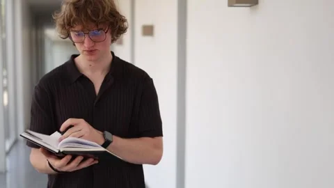 Schoolboy reviews notes before class Stockbeeldmateriaal 338277007