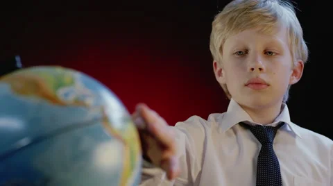 Schoolboy rotates the globe Stock Footage 62931911