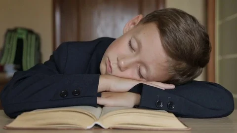 The schoolboy is sleeping with his head in his hands Stock Footage 78159243