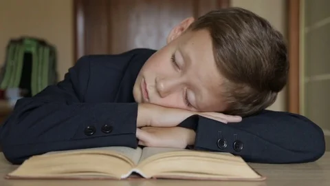 The schoolboy is sleeping with his head in his hands Stock Footage 78159342