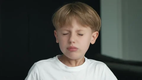 A schoolboy sneezes and snot flows from his nose. Colds and viruses in children Stock Footage 289772980
