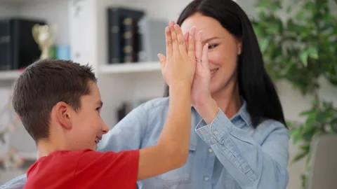 Schoolboy solves difficult math problem, gives high five to his smiling mother Stock Footage 230920235