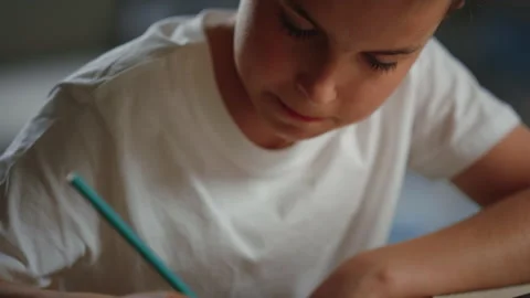 Schoolboy solving problems in notebook. Thoughtful boy studying at home. Stock Footage 142932285