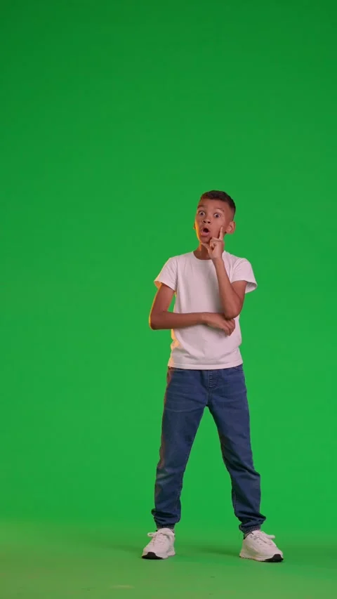 A schoolboy stands and thinks on a green screen Stock Footage 284091716
