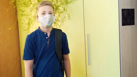 Schoolboy stands with a folder in his hands and a backpack in a room  Stock Footage 138411329