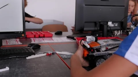 Schoolboy study in a robotics class, assemble a robot constructor. Stock Footage 154370204