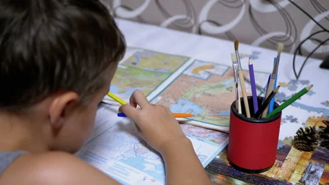 Schoolboy is Studying Map holding Pen and Pencil in Hand. Online Homeschooling Video stock 142751176