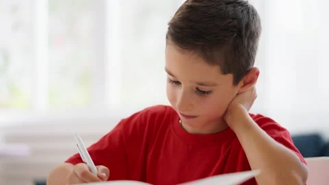 Schoolboy thinking over math problem, brain teaser, doing homework in his room Stock Footage 230919642