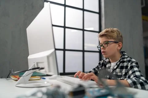 Schoolboy using computer in classroom at school 스톡 사진