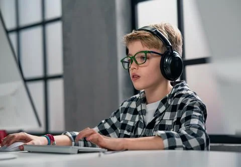 Schoolboy using computer in classroom at school 库存照片