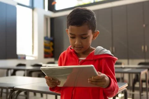 Schoolboy using digital tablet at desk in a classroom 스톡 사진