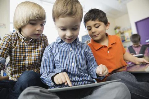 Schoolboy using digital tablet in elementary classroom Stock Photos