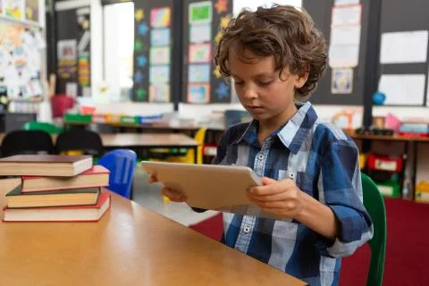 Schoolboy using digital tablet in the library Stock Photos