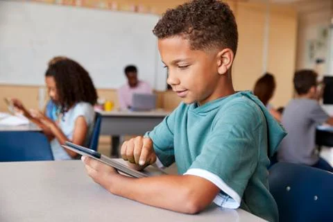 Schoolboy using tablet in elementary school class, close up 스톡 사진