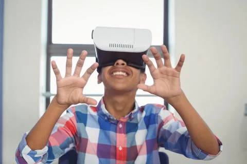 Schoolboy using virtual reality headset in classroom 스톡 사진