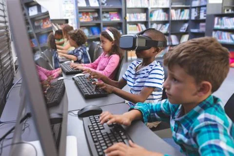 Schoolboy using virtual reality headset in computer room Stock Photos