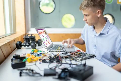 Schoolboy watching code and using laptop learning in STEM class. Edification. Stock Photos