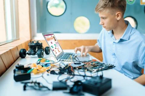 Schoolboy watching code and using laptop learning in STEM class. Edification. Stock Photos