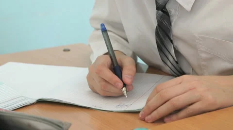 The schoolboy writing the text in the copybook Stock Footage 69001567