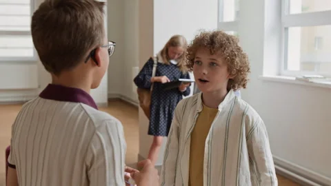 Schoolboys Greeting Each Other and Talking in School Hallway Stock Footage 345234834