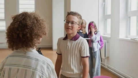 Schoolboys Greeting Each Other by Hugging in School Hallway Stock Footage 345216139