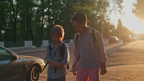 The schoolboys returning from school in a sunset time. Stock-Footage 157700284