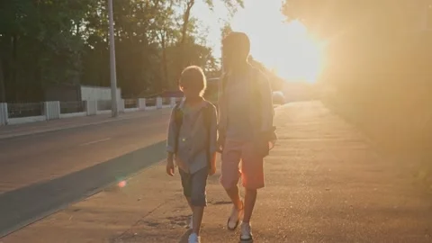 The schoolboys returning from school in a sunset time. Stock-Footage 157700326
